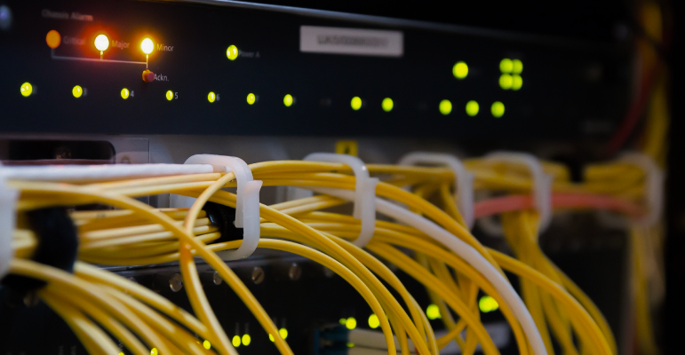 Telecommunication device operating, indicator lights on and fiber cables trunked.